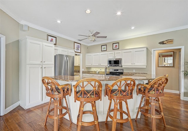 kitchen featuring white cabinets, stainless steel appliances, light stone countertops, and dark hardwood / wood-style floors