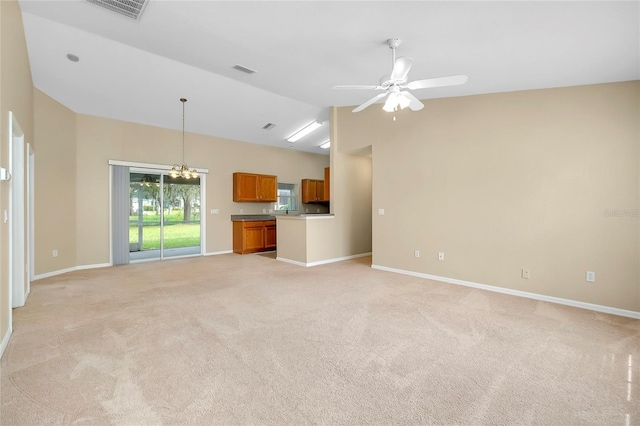 unfurnished living room featuring ceiling fan with notable chandelier, lofted ceiling, and light carpet