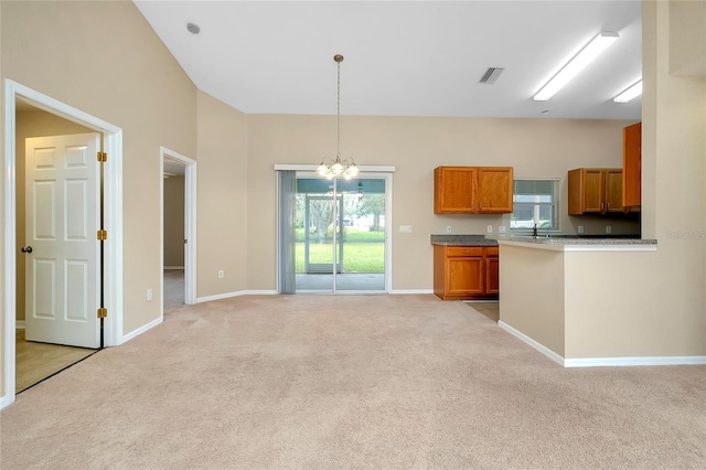 kitchen featuring decorative light fixtures, light colored carpet, and a notable chandelier