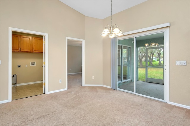 carpeted spare room with a notable chandelier