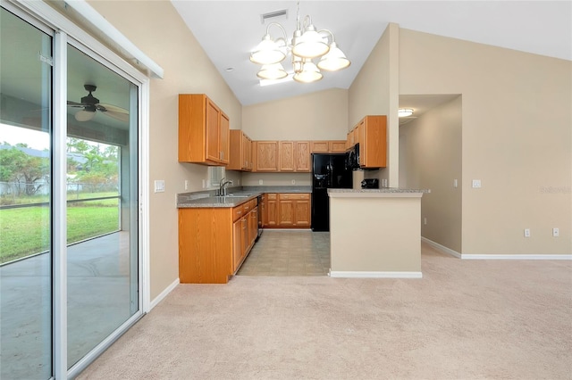 kitchen with light carpet, black refrigerator, ceiling fan with notable chandelier, sink, and pendant lighting