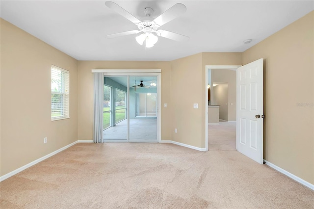 carpeted spare room featuring ceiling fan