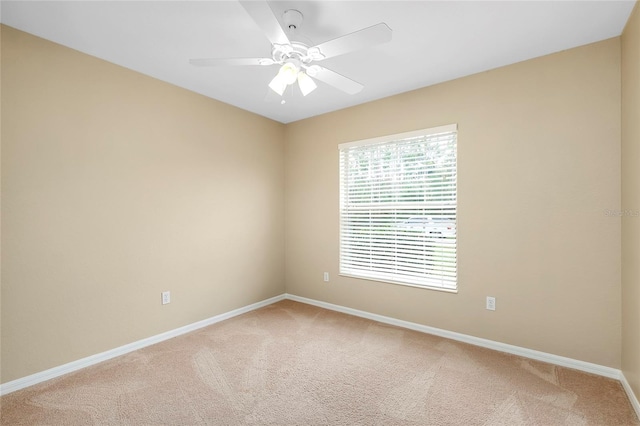 carpeted spare room featuring ceiling fan