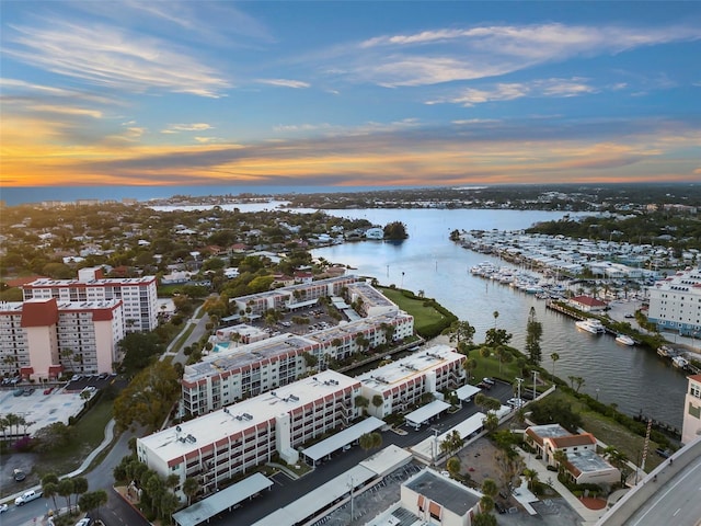 aerial view at dusk featuring a water view