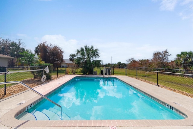 view of swimming pool featuring a yard