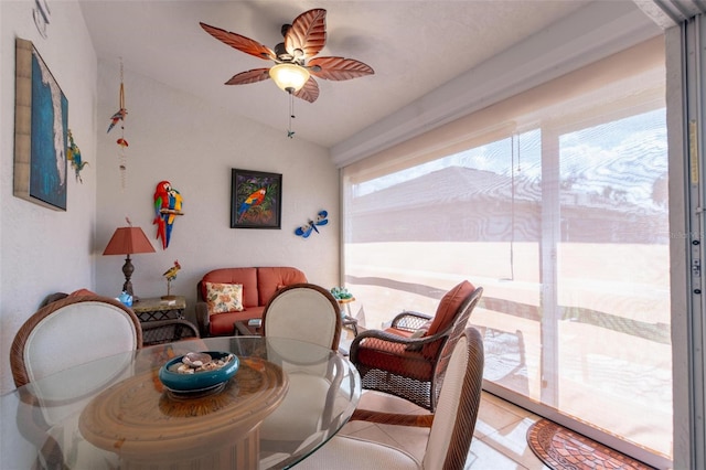 tiled dining area featuring ceiling fan and vaulted ceiling