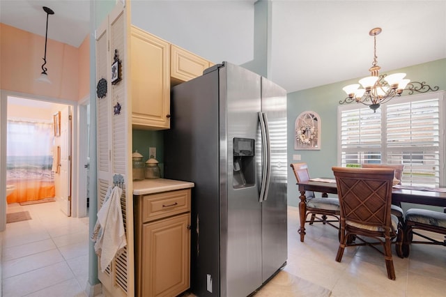 kitchen featuring light tile patterned floors, decorative light fixtures, a chandelier, and stainless steel fridge