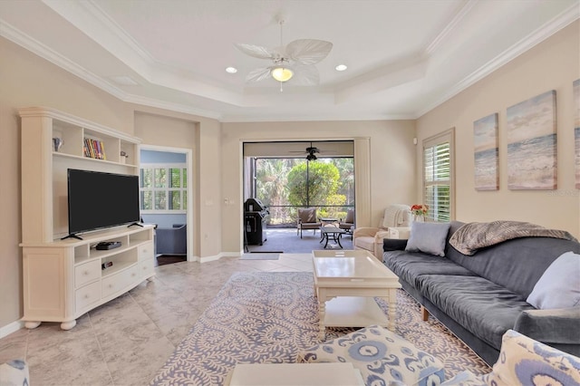 living room featuring crown molding, a tray ceiling, and ceiling fan