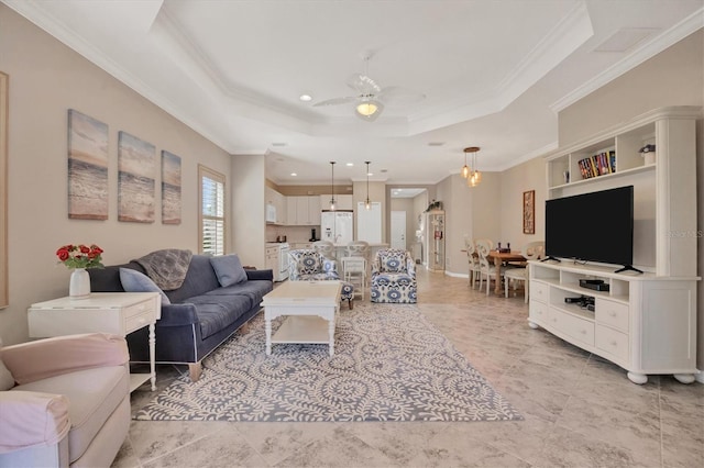 living room with ornamental molding, a raised ceiling, and ceiling fan