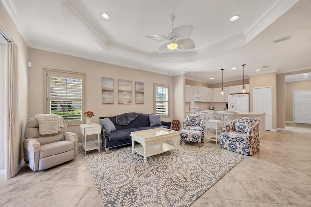 living room featuring a wealth of natural light, crown molding, a tray ceiling, and ceiling fan