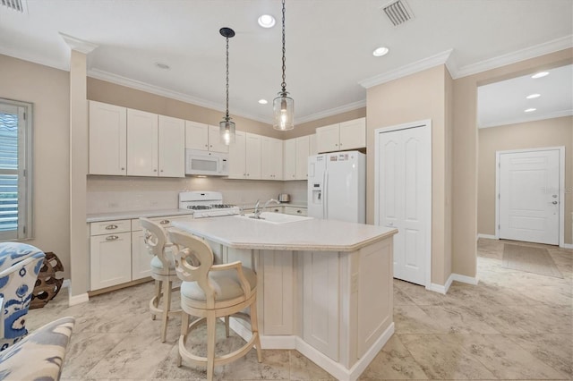 kitchen featuring white appliances, decorative light fixtures, white cabinets, crown molding, and a kitchen island with sink