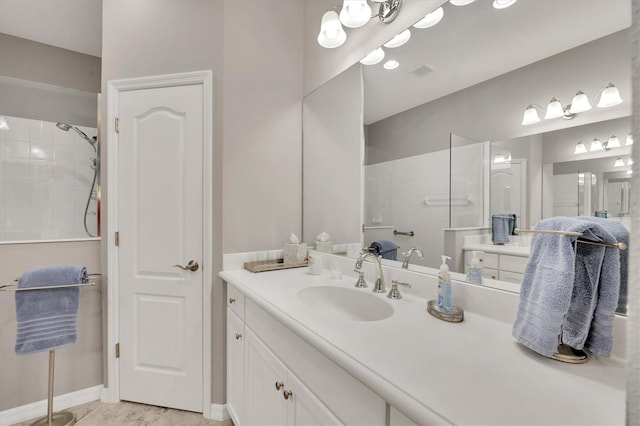 bathroom with vanity and a tile shower