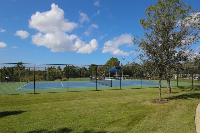 view of sport court featuring a lawn