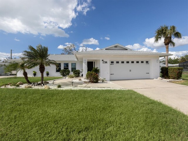 ranch-style house featuring a garage and a front lawn