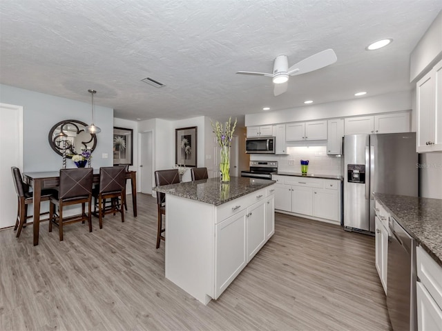 kitchen featuring white cabinets, light wood-type flooring, and stainless steel appliances