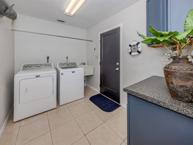 clothes washing area featuring washing machine and clothes dryer and light tile patterned flooring