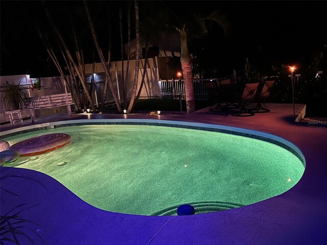 pool at twilight with a patio