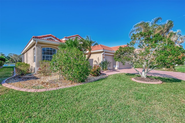 mediterranean / spanish house featuring a front yard and a garage