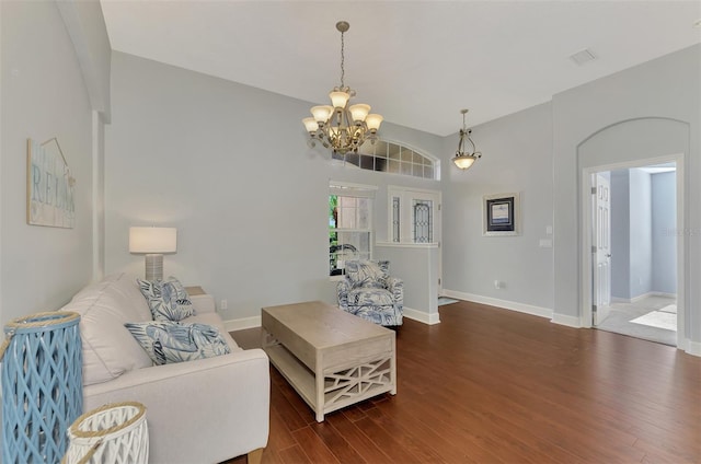 living room featuring an inviting chandelier, high vaulted ceiling, and dark wood-type flooring