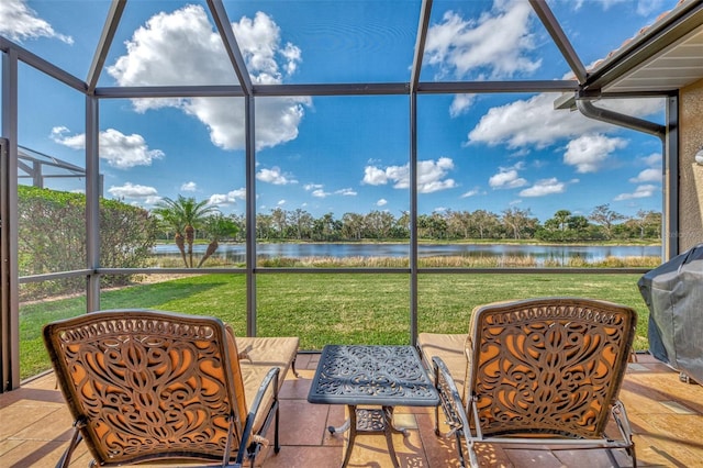 sunroom featuring a water view