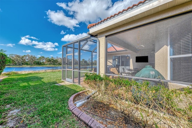 view of yard with a water view and glass enclosure