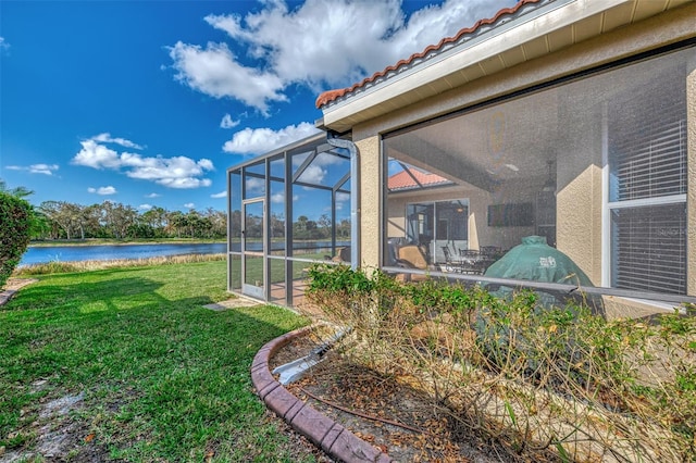 view of yard with a water view and glass enclosure