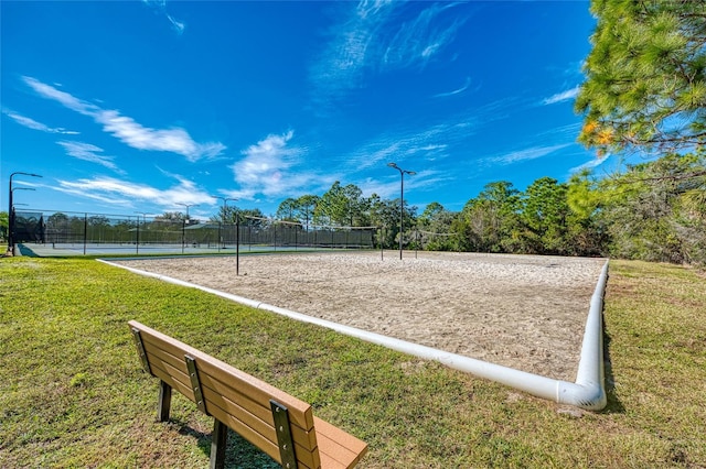 view of community with tennis court, a lawn, and volleyball court