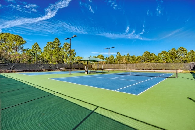 view of tennis court featuring basketball hoop