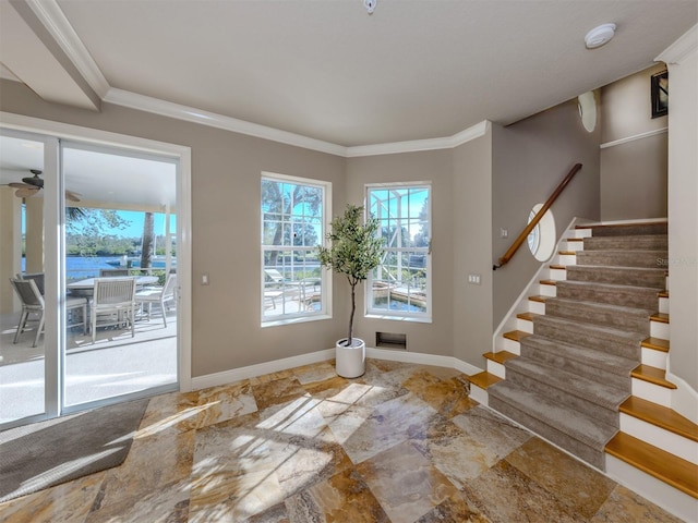 foyer entrance with a water view and ornamental molding