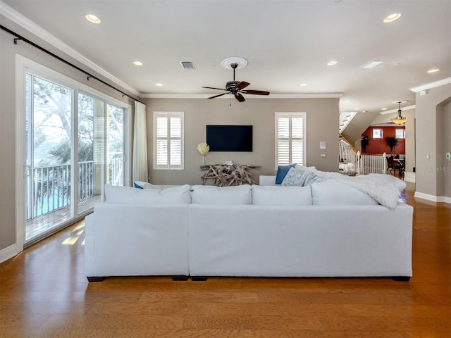 living room featuring hardwood / wood-style flooring, ceiling fan, and ornamental molding