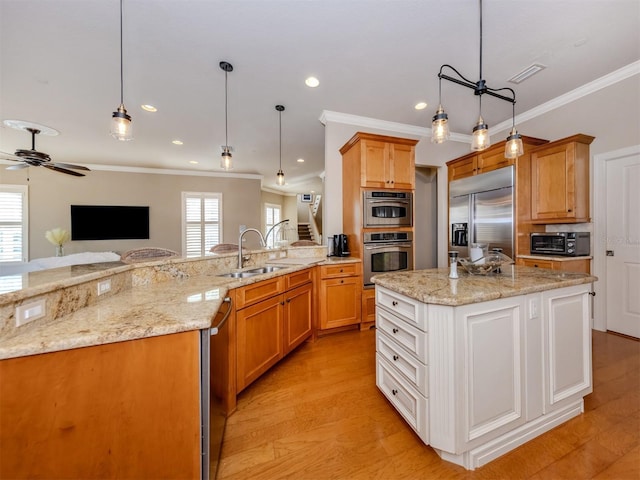 kitchen with a wealth of natural light, white cabinets, light wood-type flooring, and appliances with stainless steel finishes