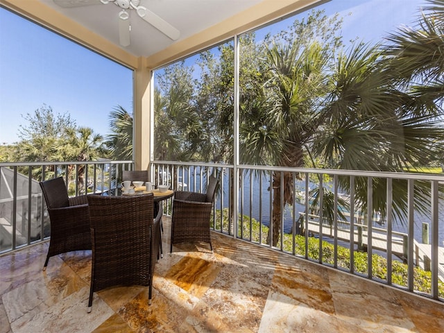 sunroom featuring a water view and ceiling fan