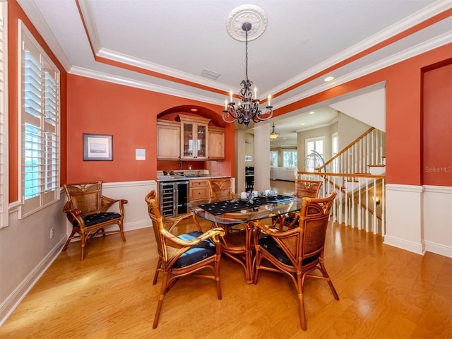 dining space with light hardwood / wood-style floors, wine cooler, and a wealth of natural light