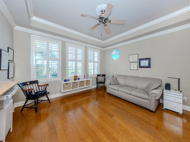 living room with crown molding, ceiling fan, a healthy amount of sunlight, and light wood-type flooring