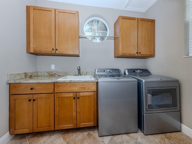 clothes washing area with washer and clothes dryer, cabinets, light tile patterned floors, and sink