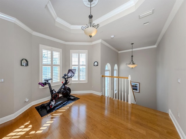 workout area featuring wood-type flooring and crown molding