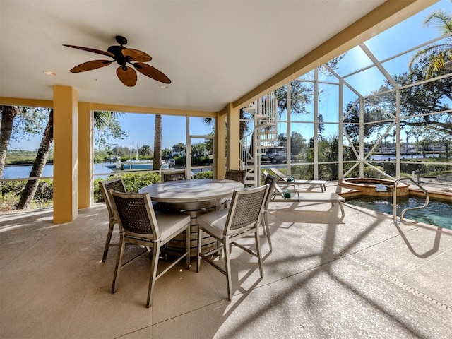 sunroom / solarium featuring ceiling fan, a water view, and a swimming pool