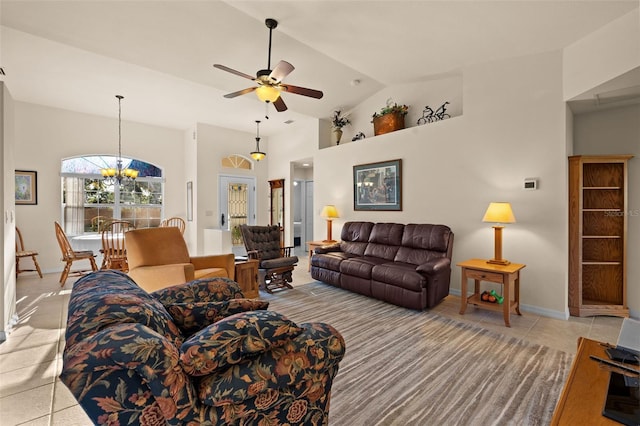 living room with light tile patterned flooring, ceiling fan with notable chandelier, and high vaulted ceiling