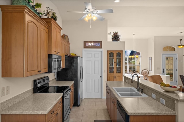 kitchen featuring sink, stainless steel appliances, pendant lighting, light tile patterned floors, and a kitchen island with sink