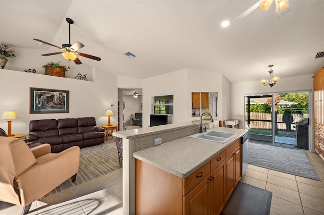 kitchen with light tile patterned floors, a kitchen island with sink, dishwasher, a notable chandelier, and sink