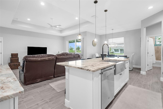 kitchen featuring white cabinetry, light stone counters, dishwasher, and a kitchen island with sink