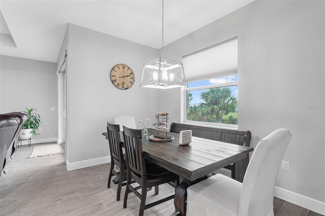 8559 Waldrep St, Port Charlotte, FL 33981 - dining area featuring a chandelier, baseboards, and wood finished floors