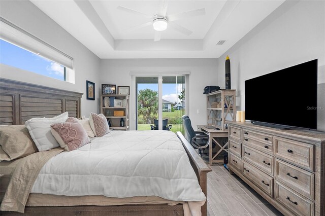 8559 Waldrep St, Port Charlotte, FL 33981 - bedroom with access to outside, a tray ceiling, multiple windows, and ceiling fan