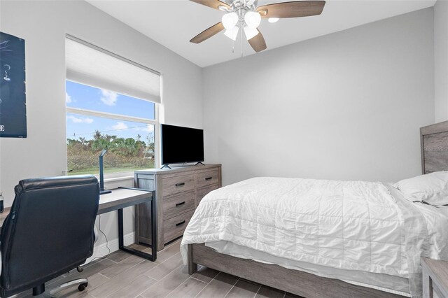 8559 Waldrep St, Port Charlotte, FL 33981 - bedroom with an office area, wood finish floors, a ceiling fan, and baseboards