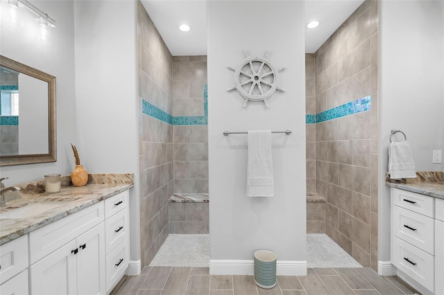 bathroom featuring vanity and tiled shower