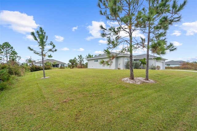 8559 Waldrep St, Port Charlotte, FL 33981 - view of grassy yard featuring a garage