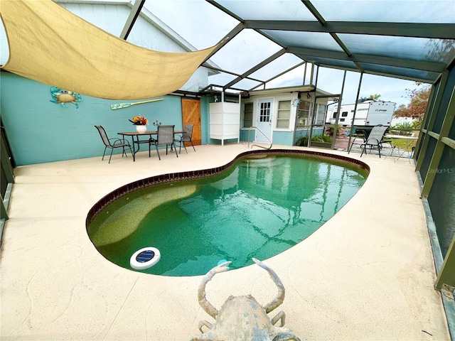 view of swimming pool with glass enclosure and a patio