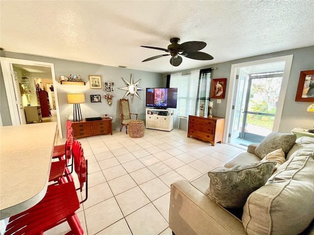 tiled living room featuring ceiling fan and a textured ceiling