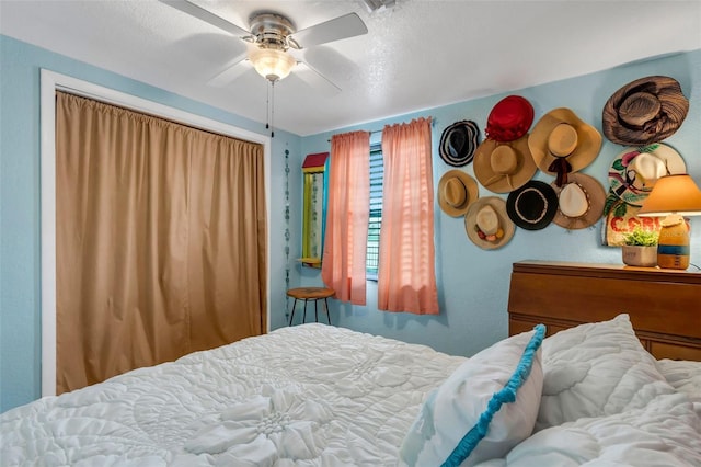 bedroom with ceiling fan and a textured ceiling