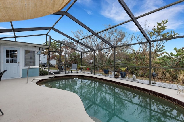 view of pool featuring glass enclosure and a patio area